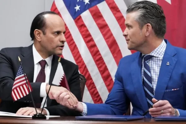 F-15 fighter jet with US and Qatari flags symbolizing joint training and interoperability.